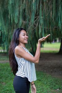 Happy young woman standing in park