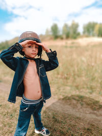 A little boy in a motorcycle helmet walks on the street