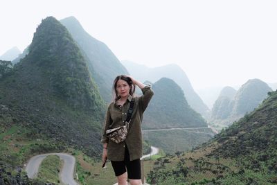 Rear view of woman standing against mountain