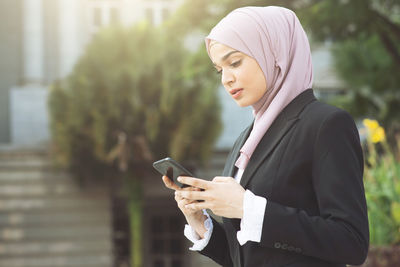 Mid adult man using mobile phone outdoors