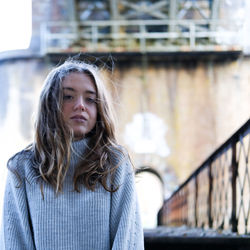 Portrait of beautiful young woman against railing