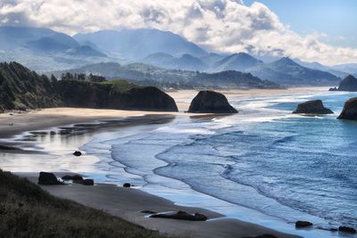 Scenic view of sea and mountains against sky