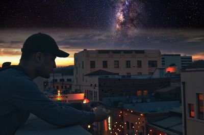  view of man using smart phone on balcony at night