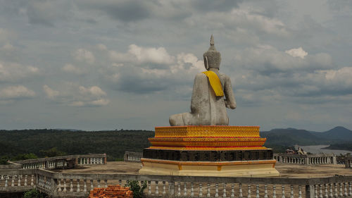 Statue of temple against cloudy sky