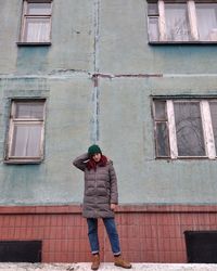 Full length of man standing against building