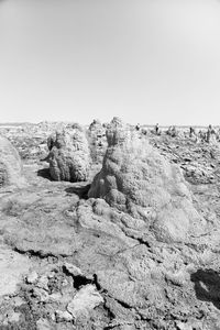 Rocks on beach against clear sky