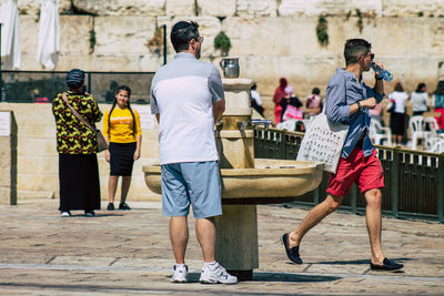 Rear view of people standing on street