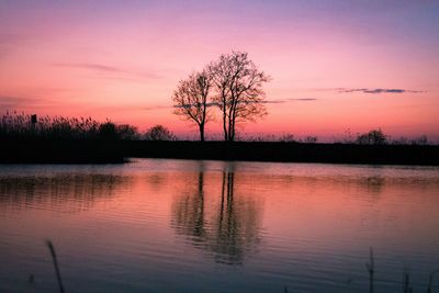 Scenic view of lake against romantic sky at sunset