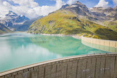 Scenic view of lake by mountains against sky