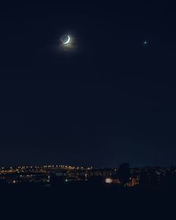 Illuminated city against sky at night