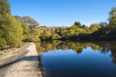 Scenic view of lake against clear blue sky