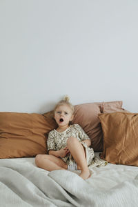 Girl on bed yawning