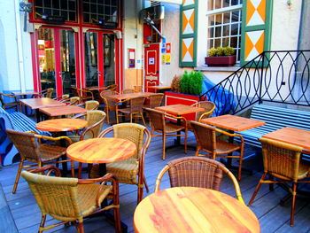 Empty chairs and tables at sidewalk cafe