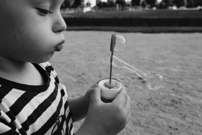 Close-up of boy blowing bubbles at playground