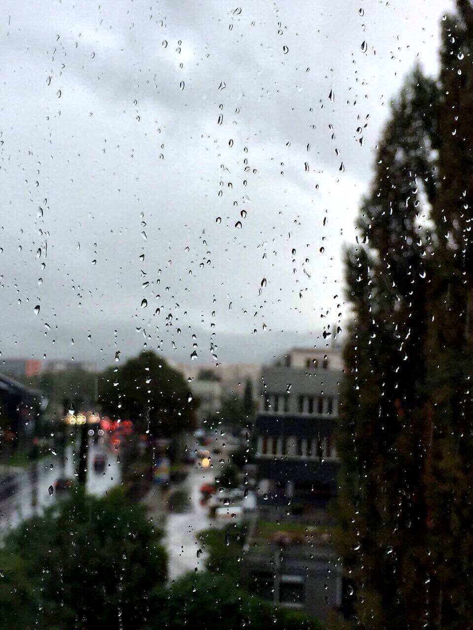 CLOSE-UP OF WET GLASS WINDOW IN RAIN