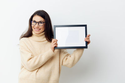 Portrait of woman holding picture frame