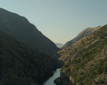 Scenic view of river amidst mountains against clear sky