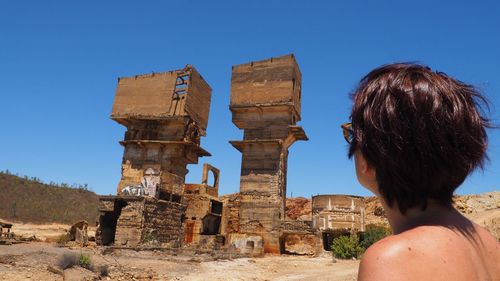 Rear view of woman at temple against clear sky