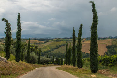 Country road against cloudy sky