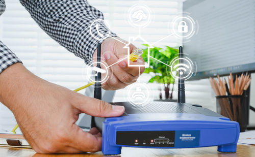 Close-up of man using smart phone on table