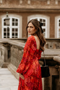 Young woman standing against building