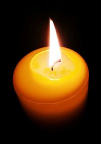 Close-up of lit candle in dark room