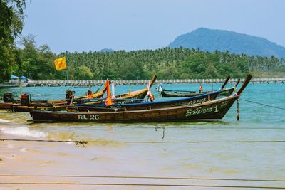 Boats moored in sea against sky