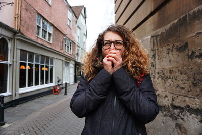 Portrait of woman standing against building