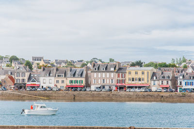 Buildings by sea against sky in city