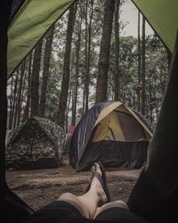 Low section of woman lying in tent