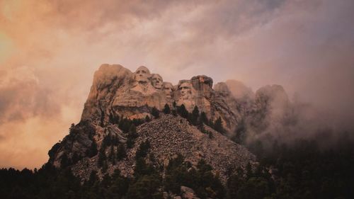 Low angle view of rock formation against cloudy sky