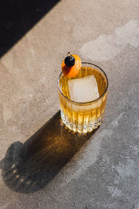 Golden hour whiskey soda highball cocktail with ice, cherry orange peel garnish