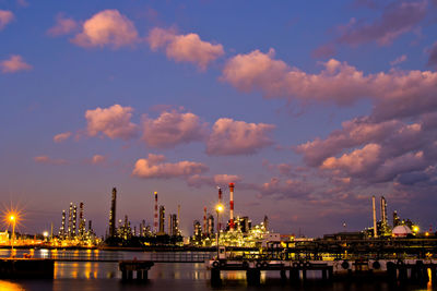 Illuminated buildings against sky at sunset