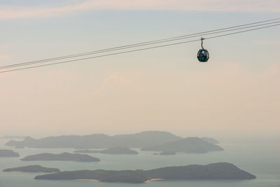 Low angle view of overhead cable car against sky