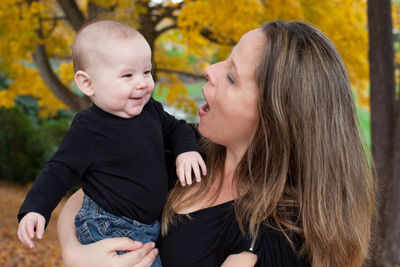 Mother playing with daughter during autumn