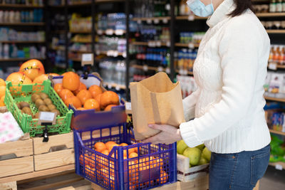 Rear view of woman standing by food in store