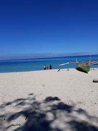 Scenic view of beach against blue sky