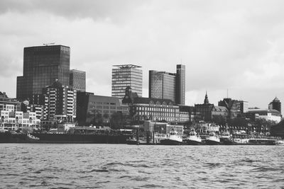 Buildings by sea against sky in city