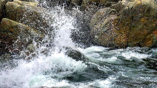 Close-up of waves splashing in sea against sky