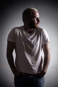 Young man standing against gray background