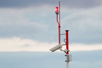 Security camera against cloudy sky