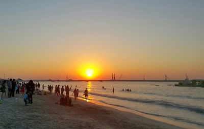 People at beach during sunset