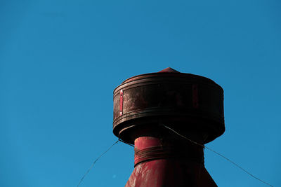 Low angle view of water tower against clear blue sky