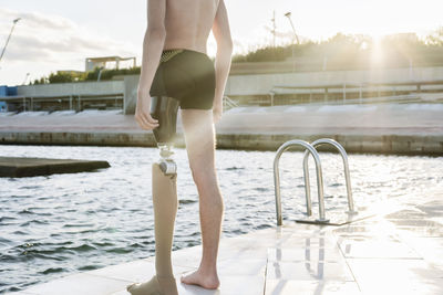 Disabled man standing on promenade during sunny day