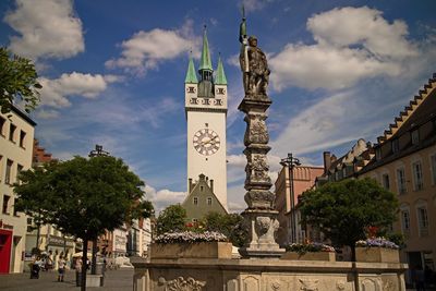 Statue amidst trees and buildings against sky