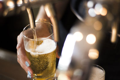 Close-up of woman hand holding beer glass