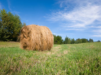 Hay bales on field against sky