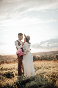 Couple holding hands on field