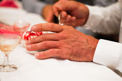 Midsection of man holding ice cream on table