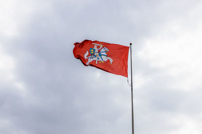 The coat of arms of lithuania. knight on a horse on a red background in the cloudy sky